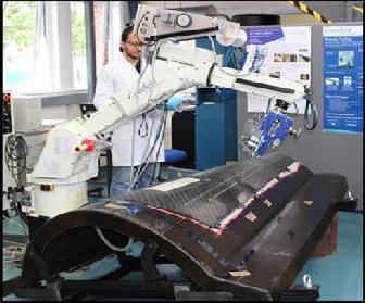 Figure 3: Tufting robot at Cranfield inserting tufts in a
        double-curvature surface.